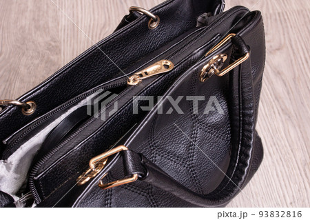 Black female handbag on a wooden background 93832816