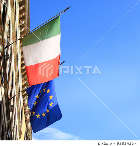 青空になびくイタリアとユーロの国旗 93834257