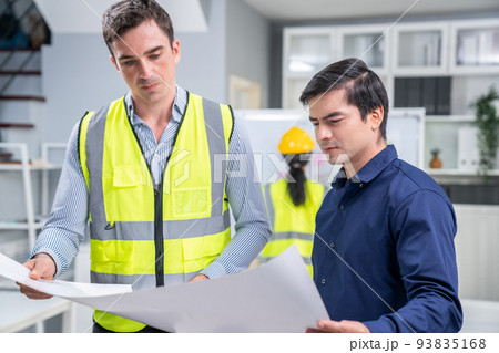 Competent investor investor discuss and brainstorm with engineers on blueprint. Competent investor investor discuss and brainstorm with engineers on blueprint. 93835168