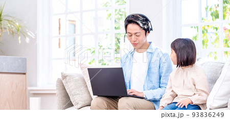 ソファに座ってノートパソコンで仕事をするパパと話しかける子供 93836249