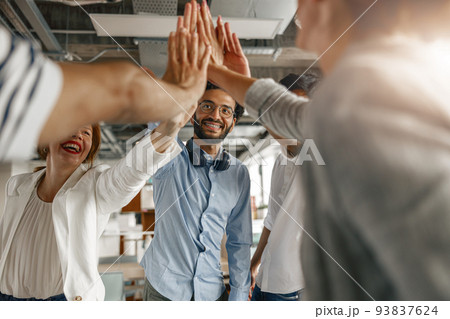 Happy group of multi ethnic coworkers stacked hands together as concept of corporate unity 93837624