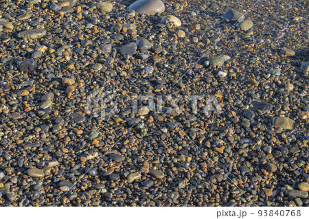 波が引いた時の石と泡 93840768