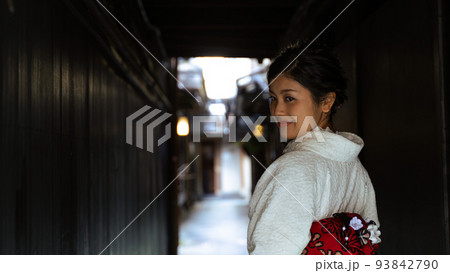 京都　和服で小道を散策中、優しく微笑む日本人女性　横顔のバストショット 93842790