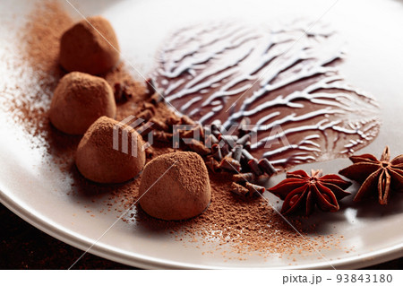 Chocolate truffles on a beige plate with chocolate sauce. Chocolate truffles on a beige plate with chocolate sauce. 93843180