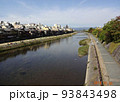 京都の鴨川。遠くに橋と京都の山々。広い川と青空。 93843498