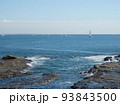 青空を背景に湘南の岩場と海。遠くに多数のヨット。 93843500