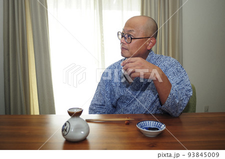 お酒楽しむ浴衣中年男性 93845009