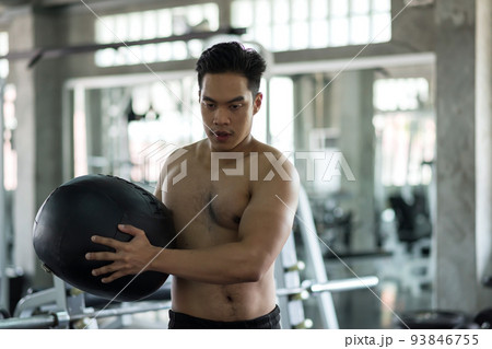 Fit Asian muscle man swing abdomen ball at fitness gym Fit Asian muscle man swing abdomen ball at fitness gym 93846755