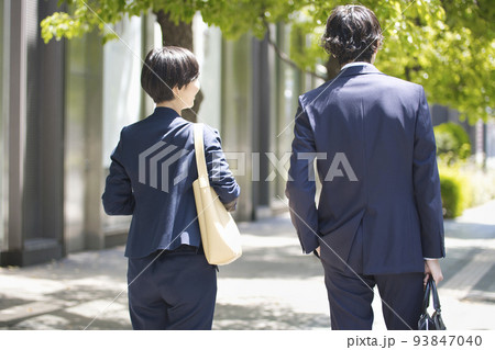 オフィス街を歩くビジネスパーソンの後ろ姿 93847040