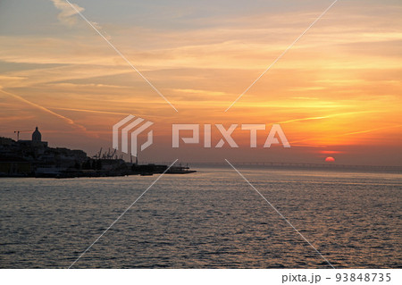 朝焼けのリスボンの旧市街の港湾風景 93848735