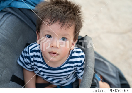 Baby boy sitting in the stroller on the beach Baby boy sitting in the stroller on the beach 93850468