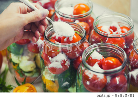 The process of preserving cucumbers and tomatoes for the winter. 93850781