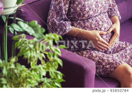 pregnant woman sitting on the sofa. waiting for the newborn. 93850784