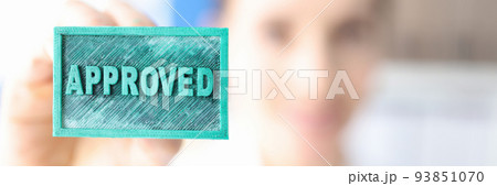 Woman holding green ink stamp approved closeup 93851070