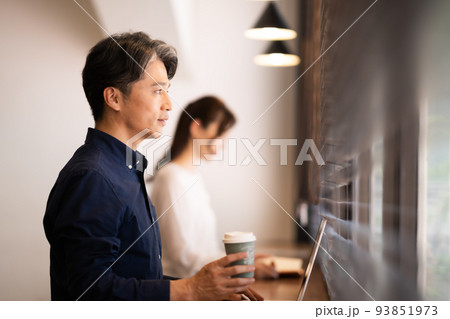 カフェでPCを広げ仕事をするミドルのビジネスマン カフェでPCを広げ仕事をするミドルのビジネスマン 93851973