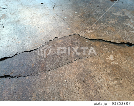 Cracked concrete ground broken at floor home or street road subside from earthquake 93852307