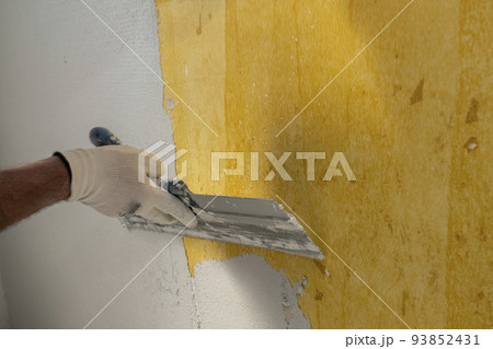 Plasterer applies plaster on the wall during repair and restoration work Plasterer applies plaster on the wall during repair and restoration work 93852431