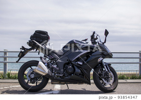 海をバッグに撮ったツーリング中のバイクの横からの写真 93854347
