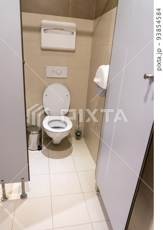 Clean empty toilet cubicle with open door in public restroom Clean empty toilet cubicle with open door in public restroom 93854584