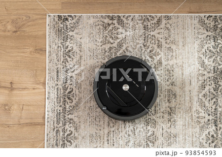 Top view of a black robotic vacuum cleaner that cleans the carpet Top view of a black robotic vacuum cleaner that cleans the carpet 93854593