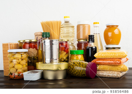 Emergency survival food set on dark wooden kitchen table 93856486