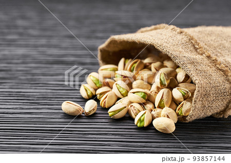 Pistachios in bag on black table with copy space. 93857144