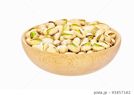 Pistachios nuts in wooden bowl isolated on white background. 93857162