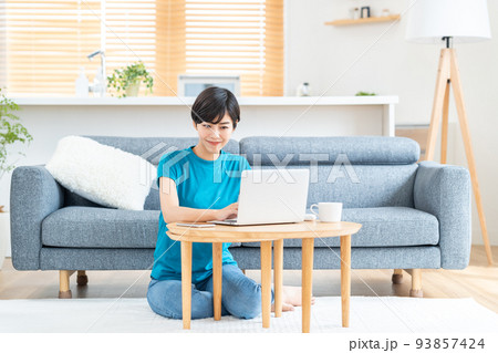 リビングでノートPCを使う女性。 93857424