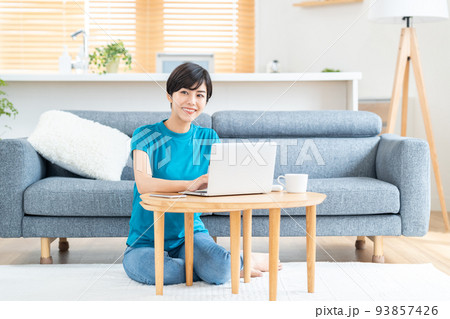 リビングでノートPCを使う女性。 93857426
