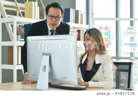 Asian business man and woman looking at computer laptop screen to discuss and working in office Asian business man and woman looking at computer laptop screen to discuss and working in office 93857538