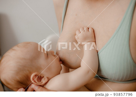 Mother feeding breast her baby at home. Baby eating mother's milk. Pretty woman breast feeding kid. Milk from mom breast is a natural medicine for children. 93857796