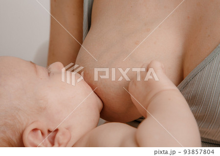 Mother feeding breast her baby at home. Baby eating mother's milk. Pretty woman breast feeding kid. Milk from mom breast is a natural medicine for children. Mother feeding breast her baby at home. Baby eating mother's milk. Pretty woman breast feeding kid. Milk from mom breast is a natural medicine for children. 93857804