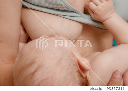Mother feeding breast her baby at home. Baby eating mother's milk. Pretty woman breast feeding kid. Milk from mom breast is a natural medicine for children. Mother feeding breast her baby at home. Baby eating mother's milk. Pretty woman breast feeding kid. Milk from mom breast is a natural medicine for children. 93857811
