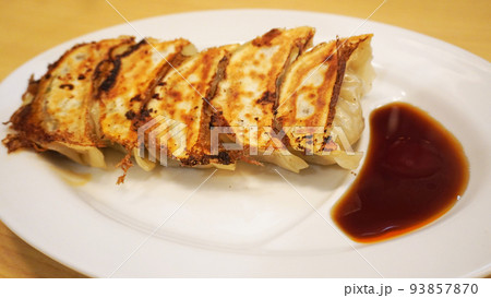お皿に盛られた餃子とタレ 93857870