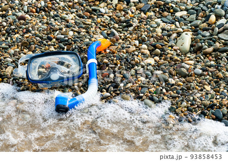 Blue snorkel and mask for diving on the pebble beach. 93858453