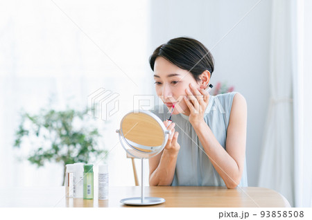 リップにグロスを塗るミドルの女性 93858508