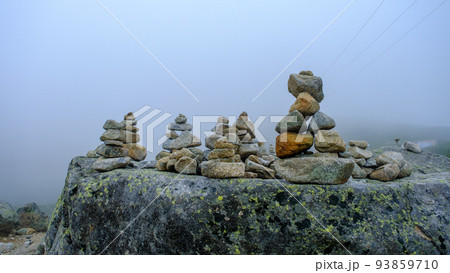 Many stone statues, pyramids are piled on the big rock. 93859710