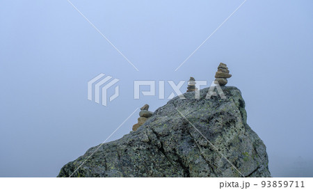 Many stone statues, pyramids are piled on the big rock. 93859711