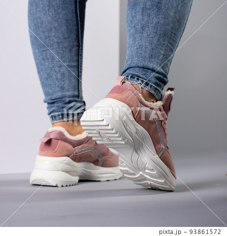 Close up demonstration of rear view of female model in warm sneakers with down inside. 93861572