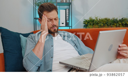Tired young man freelancer use laptop suffering from headache problem tension and migraine, stress Tired young man freelancer use laptop suffering from headache problem tension and migraine, stress 93862057