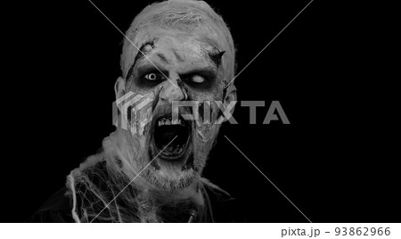 Frightening scary man with Halloween zombie bloody wounded makeup, trying to scare, face expressions 93862966
