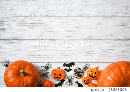 Halloween background, top view. Pumpkins and sweets on white wooden table, flat lay. 93863008