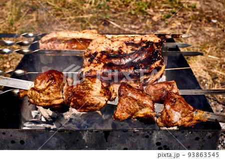 Delicious piece of meat pork beef fried over the fire mangal at a picnic. 93863545