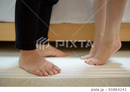 ベッドの上で立って抱き合ってキスするカップルの足元イメージ　日本人　アジア人 93864241