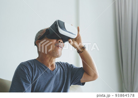 Excited Asian Senior man wearing VR goggles 93864578
