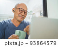 Smiling Asian Senior man using laptop 93864579