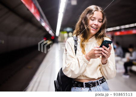 Young european female with mobile waiting the metro Young european female with mobile waiting the metro 93865513