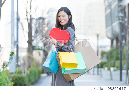 たくさんの買い物袋を抱える女性 たくさんの買い物袋を抱える女性 93865637