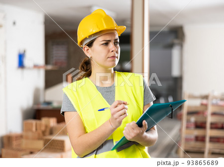 Woman taking notes on indoor construction site 93865689