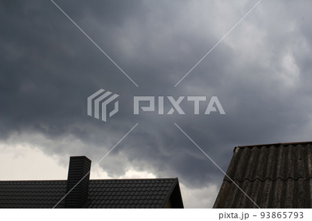 Defocus steel roof on dark sky background. Dark rain clouds above the modern roof. Roof with new black roofing tiles double flap on residential property. Dramatic sky. Out of focus Defocus steel roof on dark sky background. Dark rain clouds above the modern roof. Roof with new black roofing tiles double flap on residential property. Dramatic sky. Out of focus 93865793